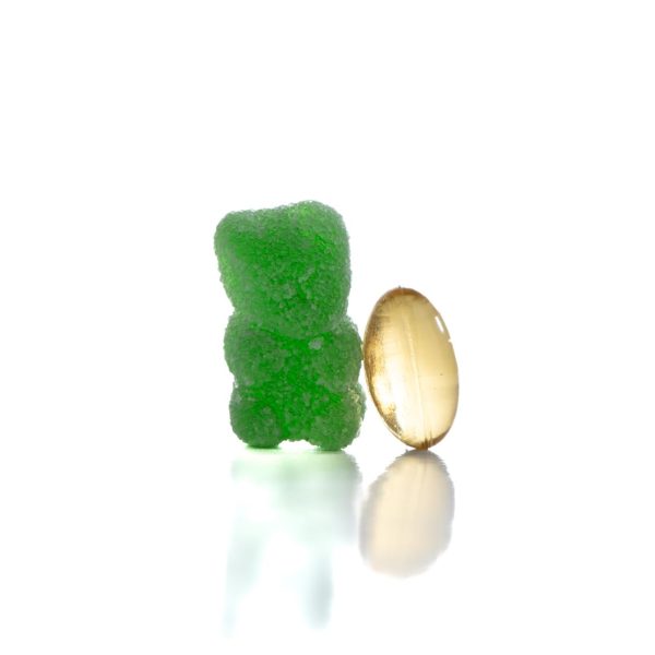 A CBD Softgel next to a CBD gummy to show size comparison.