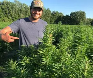 Sam with flowering hemp plants in Vermont