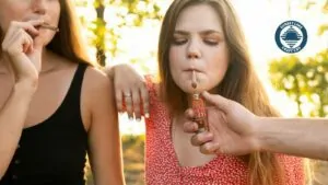 A woman smoking a CBD hemp flower preroll
