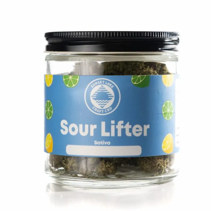 A jar containing one ounce of Sour Lifter Hemp Flower from Sunset Lake CBD. The label is blue and covered with lemon and lime glyphs.